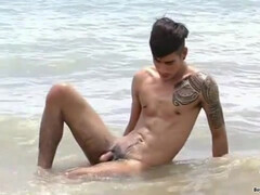 Красивый парень на пляже сольно удовлетворяет себя